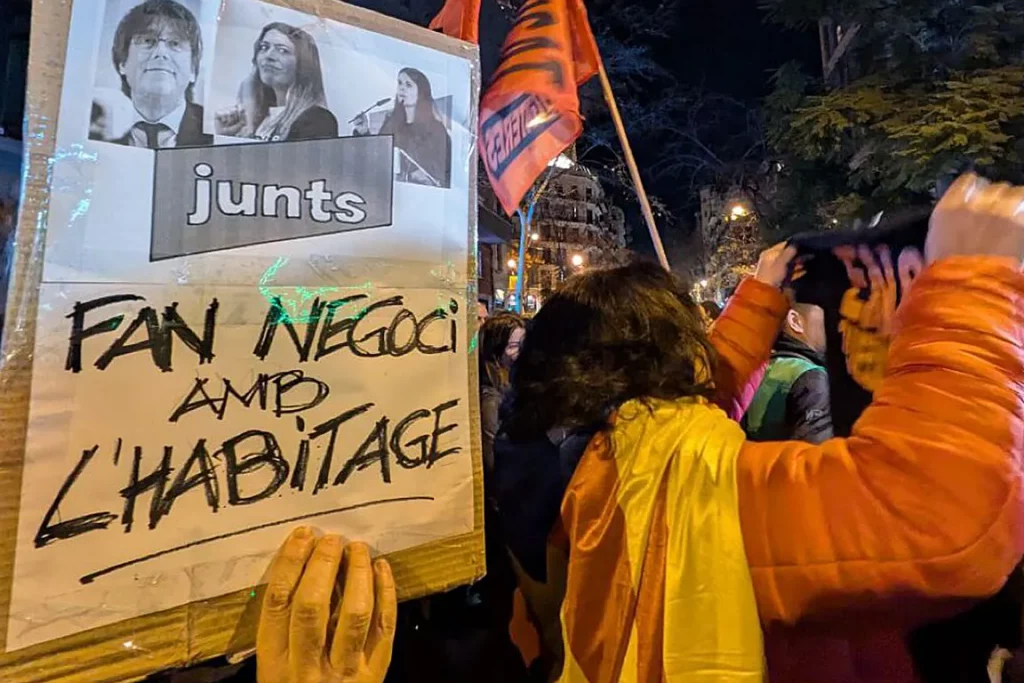 Colectivos contra los desahucios se manifiestan ante la sede de Junts como protesta por su voto en contra del decreto ómnibus en el Congreso de los Diputados.